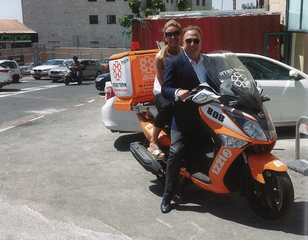 Miles and Kelly riding an Ambucycle at United Hatzalah